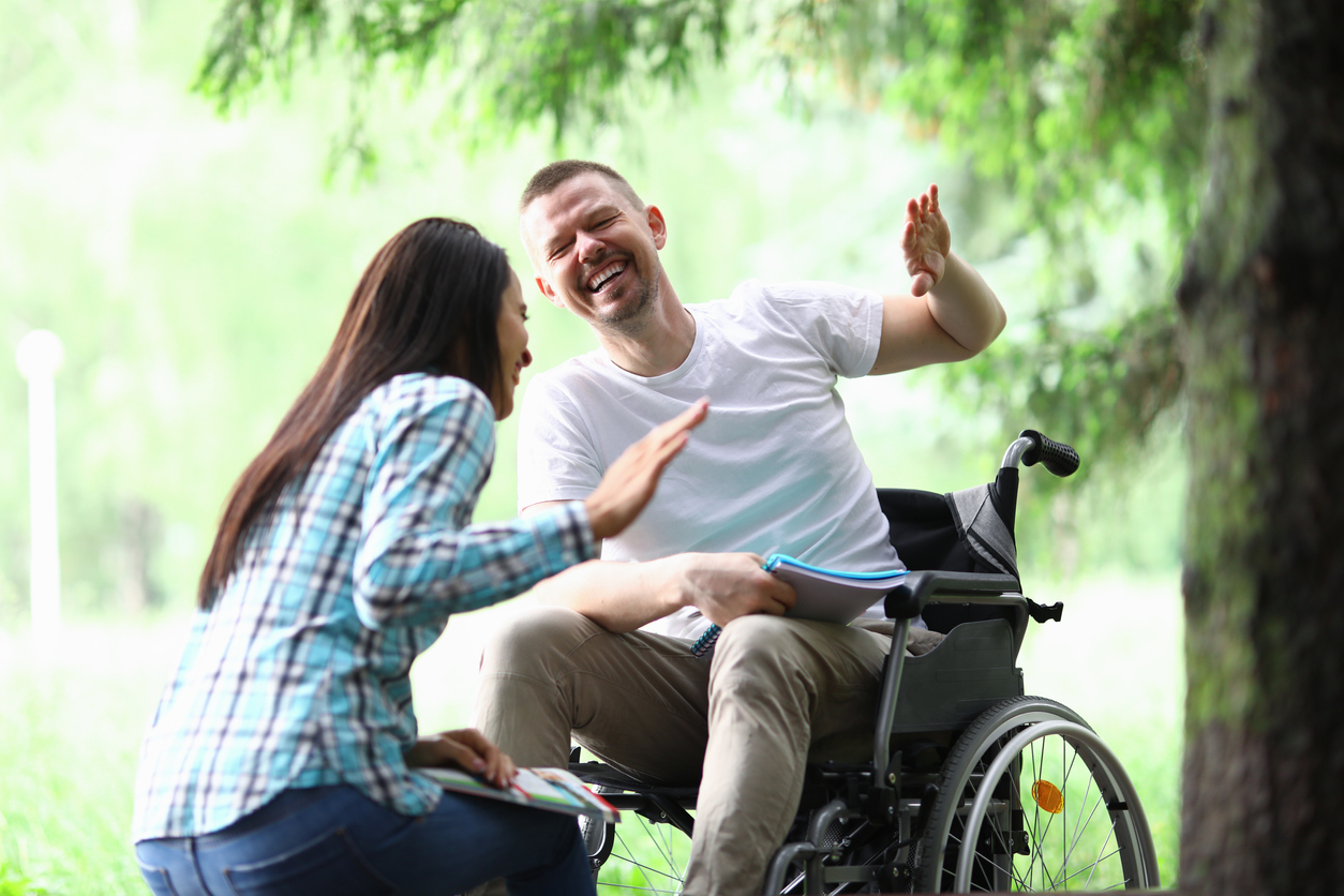 Male disabled man with girlfriend smiling on park walk portrait